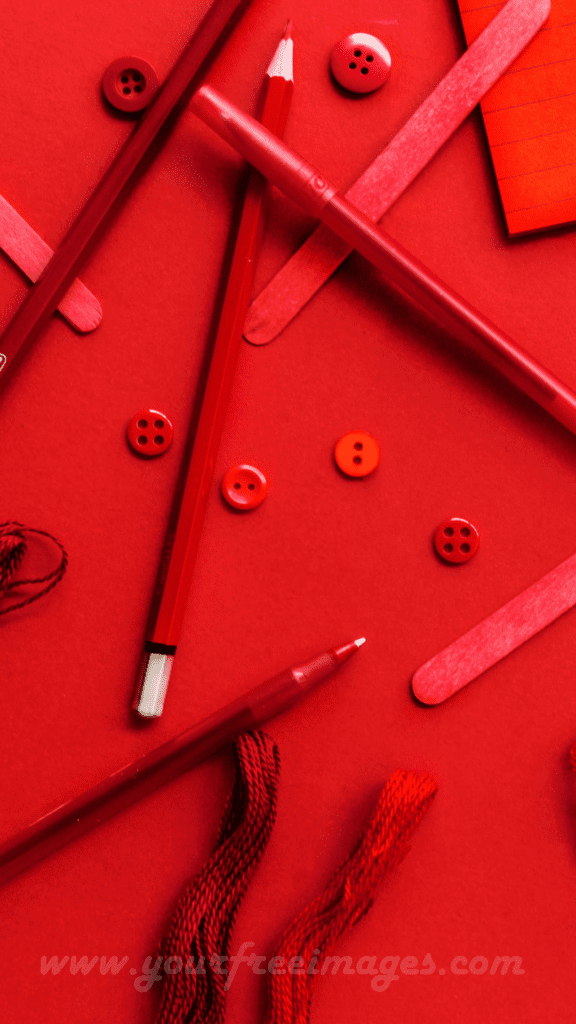 Aesthetic stationery items in red hues on a black background